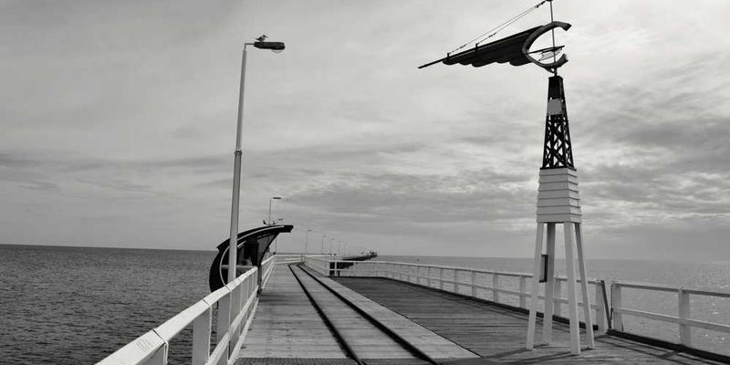 一位读者在阅读一本打开的书籍，旁边有一本笔记本，用来记录阅读心得