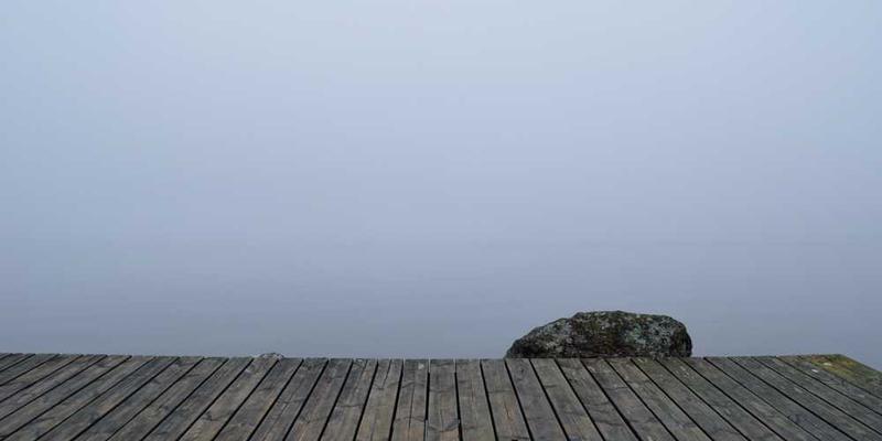 一位游客在社区的公园里拍照留念，背景是充满生活气息的街道和悠闲的老人。